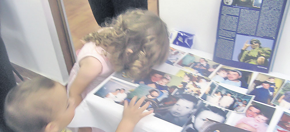 Amalia (2 ani) şi Mihai (un an şi trei luni) sărută fotografiile tatălui lor