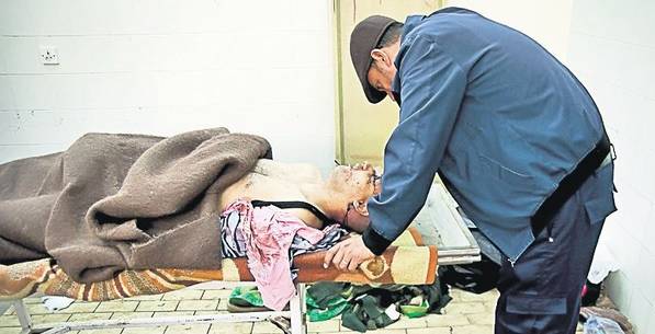 Un libian plânge aplecat asupra cadavrului fratelui său, ucis de oamenii dictatorului