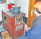 Bărbatul își gătește singur pe o plită învechită...