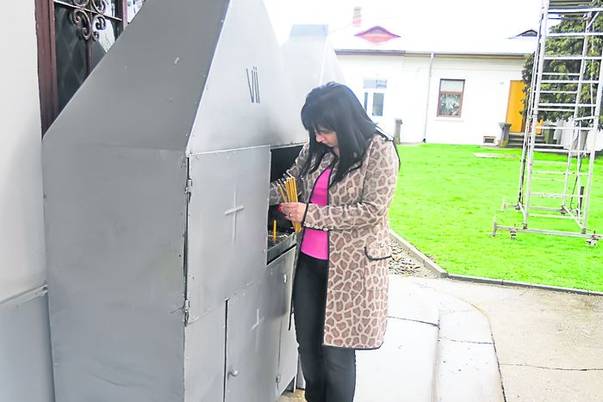 Carmen a aprins câteva lumânări în curtea bisericii