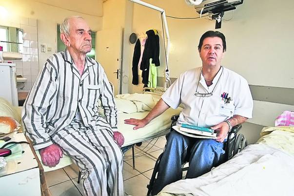Doctorul Gelu Onose (dreapta) se deplasează printre paturile pacienţilor săi în scaun cu rotile / foto: Evenimentul Zilei