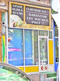 Pe firma unei case de amanet, proprietarul îi sfătuieşte pe bucureşteni să-şi vândă aurul