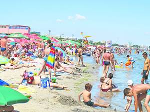 Când nu au mai avut loc pe nisip, turiştii s-au aşezat la plajă în apă