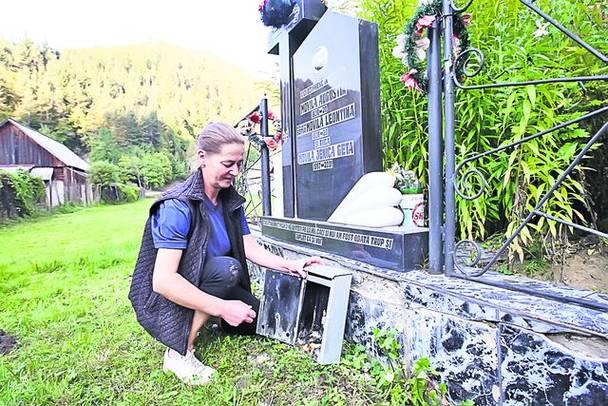 Femeia aprinde lumânări la mormintele tuturor rudelor