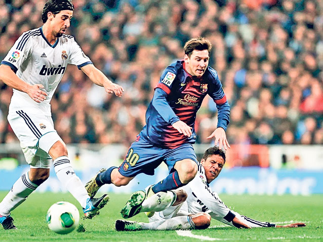 Messi (în albastru), luat în primire de doi madrileni