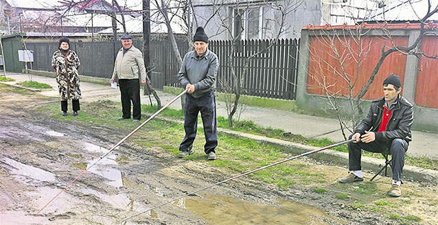Sădesc porumb pe stradă! Furia s-a transformat în resemnare! Pentru că autorităţile nu le-au asfaltat şoseaua, câţiva ploieşteni fac haz de necaz