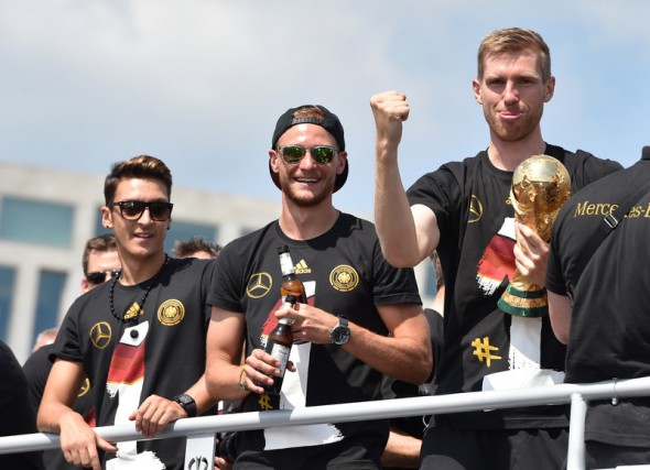 Mesut OezilBenedikt Hoewedes și Per Mertesacker se bucură alături de fani pentru cel de-al patrulea titlu mondial. Foto: EPA
