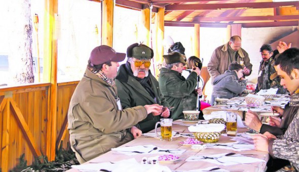 Omul de afaceri Ion Tiriac discuta cu invitatii sai, in timpul mesei organizate inainte de a doua partida a vanatorii de mistreti de la Balc, judetul Bihor