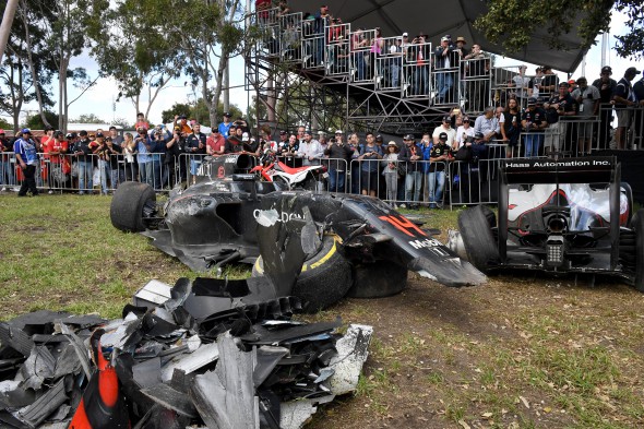epa05221789 Safety marshals pile up debris after a crash involving the cars Spanish Formula One driver Fernando Alonso of McLaren-Honda (L) and Mexican Formula One driver Esteban Gutierrez (R), during the Australian Formula One Grand Prix at the Albert Park circuit in Melbourne, Australia, 20 March 2016. EPA/JOE CASTRO AUSTRALIA AND NEW ZEALAND OUT